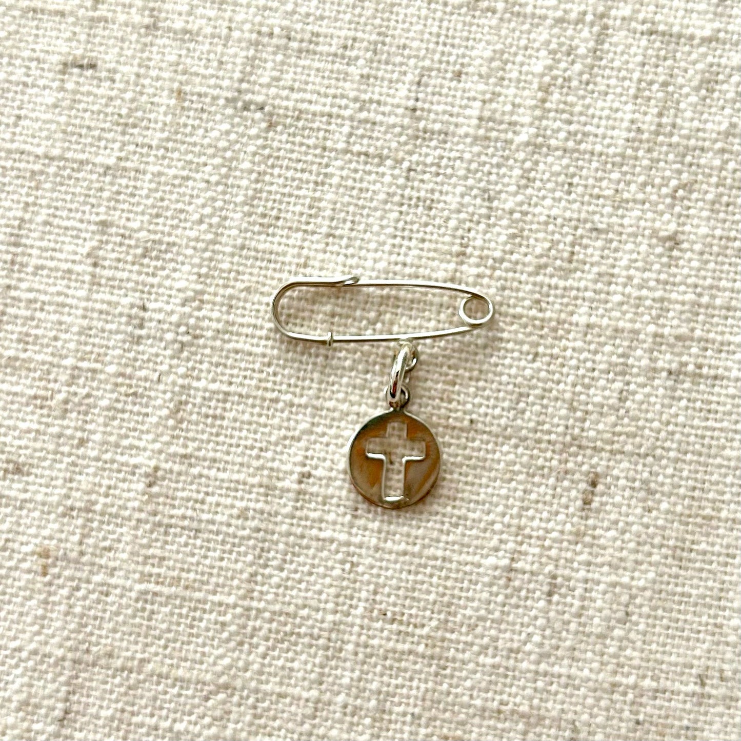 Silver safety pin with cut - out cross medal